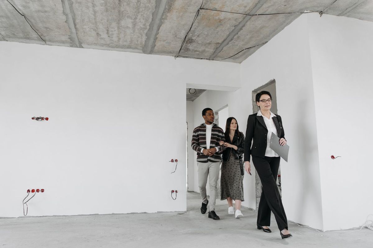 Drie personen overlopen samen een woning in renovatie