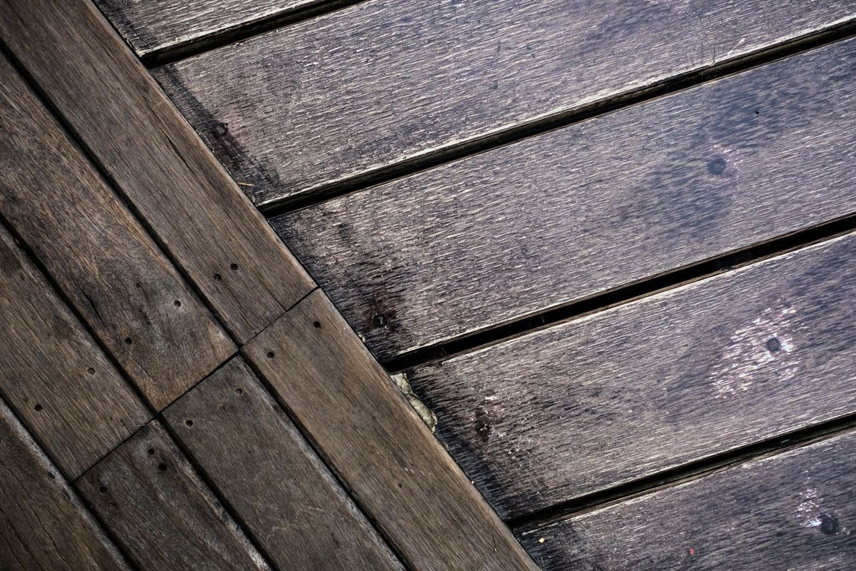 Close-up van een houten vloer met sporen van normaal gebruik